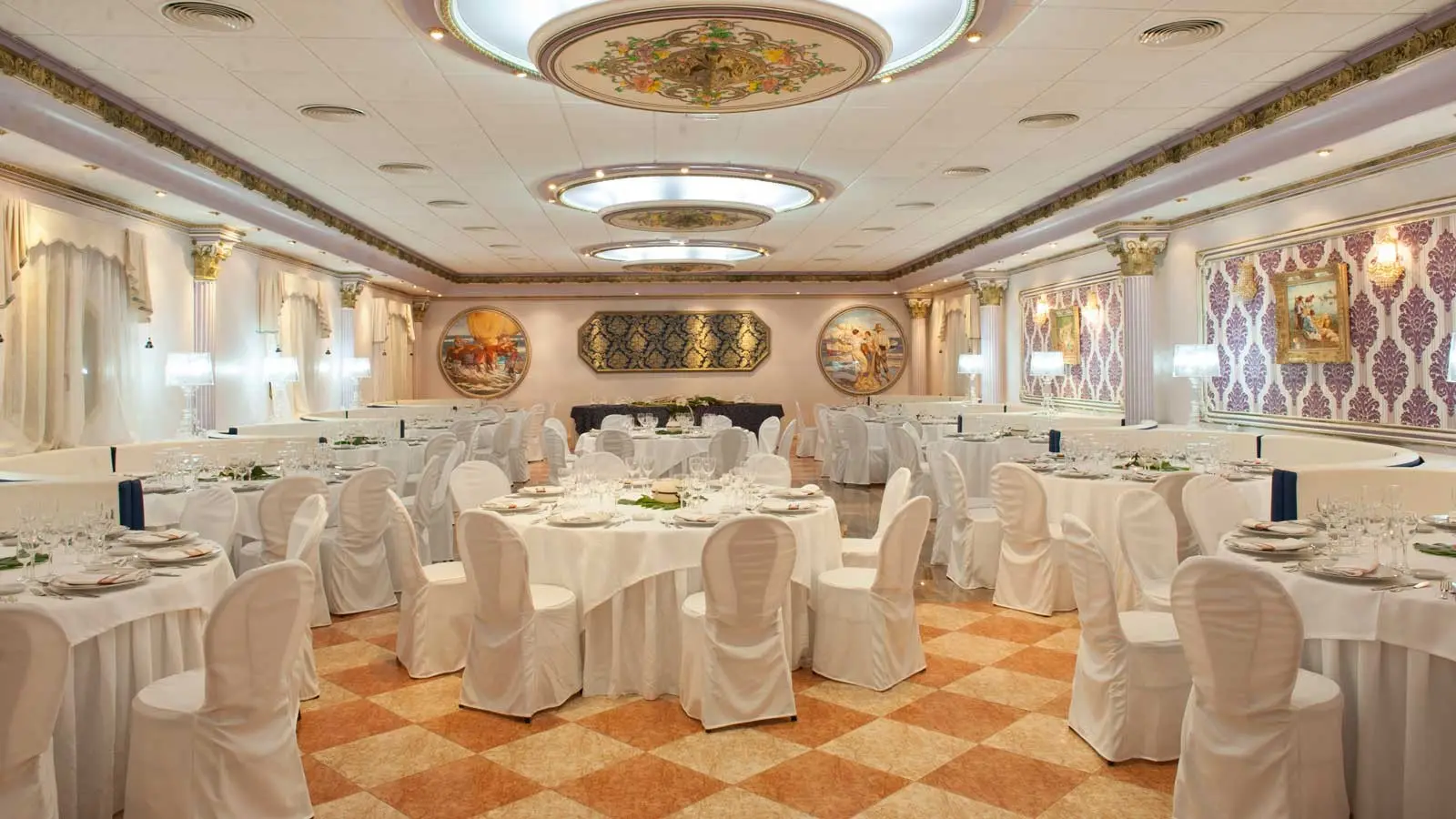 El Salón Amanecer: una sala blanca con techos pintados, columnas doradas y sillas con fundas blancas